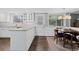 Modern kitchen with white cabinets, a large window, and a dining area with a table at 3966 S Magnolia Way, Denver, CO 80237