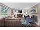 Inviting living room boasts a brick fireplace, built-in shelving, and comfortable seating, bathed in natural light at 3966 S Magnolia Way, Denver, CO 80237