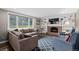 Comfortable living room features a cozy brick fireplace, built-in shelves, and ample seating for relaxation at 3966 S Magnolia Way, Denver, CO 80237