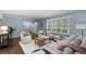 Comfortable blue living room with hardwood floors, neutral seating, and a bay window at 3966 S Magnolia Way, Denver, CO 80237