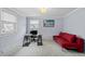 Versatile office space with a desk, red futon, and two windows for natural light at 3966 S Magnolia Way, Denver, CO 80237