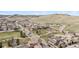 Aerial view of the neighborhood with lush green spaces, winding roads, and beautiful mountain views at 10162 Bluffmont Ln, Lone Tree, CO 80124