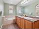 Relaxing bathroom with a double vanity, large mirror, and separate soaking tub at 10162 Bluffmont Ln, Lone Tree, CO 80124