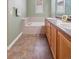 Bathroom featuring a double vanity, soaking tub, and tile flooring at 10162 Bluffmont Ln, Lone Tree, CO 80124
