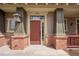 Inviting front entrance featuring a red door, brick accents, and a charming lantern at 10162 Bluffmont Ln, Lone Tree, CO 80124