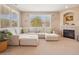 Bright living room with a large sectional, fireplace and large sunny window at 10162 Bluffmont Ln, Lone Tree, CO 80124