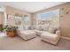 Cozy living room featuring a large sectional sofa, neutral tones, and natural light from a large window at 10162 Bluffmont Ln, Lone Tree, CO 80124