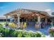 Outdoor patio under a wood pergola featuring yellow Adirondack chairs and lovely landscaping at 10162 Bluffmont Ln, Lone Tree, CO 80124