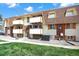 Exterior view of a condo building with balconies, manicured lawns, and visible unit number 6 at 10211 Ura_ Ln # 101, Thornton, CO 80260