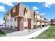 Charming multi-story condo building with brick accents, balconies, and well-maintained landscaping under a blue sky at 10211 Ura_ Ln # 101, Thornton, CO 80260
