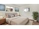 Bright bedroom features a large window, a queen bed and neutral tones at 10211 Ura_ Ln # 101, Thornton, CO 80260