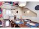 Stylish dining area featuring a wooden table, modern lighting, and an open view into the bright, white kitchen at 852 Kalamath St, Denver, CO 80204