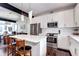 Modern kitchen with white cabinets, stainless steel appliances, and a breakfast bar at 852 Kalamath St, Denver, CO 80204