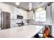 Bright, modern kitchen features white cabinets, stainless steel appliances, and a spacious island with barstool seating at 852 Kalamath St, Denver, CO 80204
