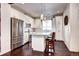 Modern white kitchen with stainless steel appliances, a center island with seating, and hardwood floors at 852 Kalamath St, Denver, CO 80204