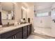 Bathroom with dual vanity, quartz countertop, and glass-enclosed shower at 6211 Stable View St, Castle Pines, CO 80108