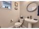 Powder room featuring vanity, toilet, decorative mirror and wall art at 6211 Stable View St, Castle Pines, CO 80108