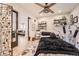 Bright bedroom featuring dark sliding doors, light wood floors, and shelves with decor accents at 6211 Stable View St, Castle Pines, CO 80108