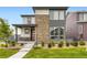 Beautiful home with a stone accent wall, inviting porch with chairs, and manicured front lawn at 6211 Stable View St, Castle Pines, CO 80108