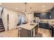 Bright kitchen features an island with marbled countertop and seating, leading to an outdoor patio at 6211 Stable View St, Castle Pines, CO 80108