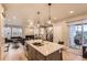 Open floorplan of kitchen featuring an island with seating looking into the dining and living room at 6211 Stable View St, Castle Pines, CO 80108