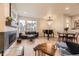 Bright living room boasts large windows, a fireplace, and an elegant chandelier at 6211 Stable View St, Castle Pines, CO 80108