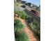 Rock and grass landscaped side yard featuring wood pavers and modern fence at 6211 Stable View St, Castle Pines, CO 80108