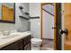 Stylish half bathroom with modern fixtures, floating shelves, and a dark wood vanity at 17051 Wellington Dr, Parker, CO 80134