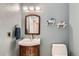 Cozy half bathroom with wood vanity, light blue walls, and white toilet at 1793 E 164Th Pl, Brighton, CO 80602