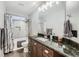 Well-lit bathroom with granite countertop vanity, tile flooring, tub and shower at 1793 E 164Th Pl, Brighton, CO 80602