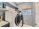 Efficient laundry area features modern washer and dryer, storage shelves and tiled flooring at 1793 E 164Th Pl, Brighton, CO 80602