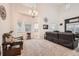 Bright living room featuring large windows, high ceilings, chandelier, plush carpeting, and comfortable seating at 1793 E 164Th Pl, Brighton, CO 80602