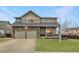 Inviting home featuring stone accents, a well-maintained lawn, and an attached two-car garage at 1793 E 164Th Pl, Thornton, CO 80602