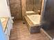 Bathroom featuring a standalone tub, a vanity with a sink, and updated tile throughout at 5688 Alcott St, Denver, CO 80221