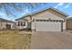 Charming single-story home featuring a two-car garage, a well-maintained lawn and a cozy front porch at 5688 Alcott St, Denver, CO 80221