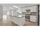 Modern kitchen featuring skylight, white cabinets, stainless steel appliances, and a kitchen island at 5688 Alcott St, Denver, CO 80221