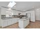 Modern kitchen featuring skylight, white cabinets, stainless steel appliances, and a kitchen island at 5688 Alcott St, Denver, CO 80221