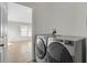 Modern laundry room with front load washer and dryer, and neutral paint at 5688 Alcott St, Denver, CO 80221