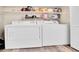 Efficient laundry room with full-size washer and dryer, plus ample storage space on shelving above at 2074 Oakcrest Cir, Castle Rock, CO 80104