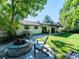 Relaxing backyard area with a fire pit, comfortable seating, and lush green lawn under a shade tree at 4071 S Dahlia St, Cherry Hills Village, CO 80113