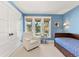 Serene bedroom with blue walls, a large window, and a cozy armchair creating a relaxing atmosphere at 4071 S Dahlia St, Cherry Hills Village, CO 80113