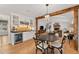 Charming dining area with modern table, wine rack, beverage cooler, wood floors, and adjacent to living room with fireplace at 4071 S Dahlia St, Cherry Hills Village, CO 80113