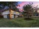 Charming two-story home with stone accents, a manicured lawn, and mature trees under a colorful sunset sky at 4071 S Dahlia St, Cherry Hills Village, CO 80113