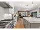 Modern kitchen with stainless steel appliances, marble countertops, open layout, connecting to the living room with wood floors at 4071 S Dahlia St, Cherry Hills Village, CO 80113