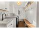 Well-organized laundry room with brick floor, white cabinets, modern washer and dryer, built-in storage, and bright lighting at 4071 S Dahlia St, Cherry Hills Village, CO 80113