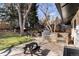 Outdoor kitchen featuring a stainless steel grill, stone accents, and patio seating in a landscaped yard at 4071 S Dahlia St, Cherry Hills Village, CO 80113