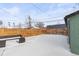 View of a snow covered back yard with a wooden fence and outdoor seating at 850 Grove St, Denver, CO 80204