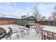 View of a snow covered back yard featuring the detached garage and outdoor furniture at 850 Grove St, Denver, CO 80204