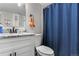 Clean bathroom featuring a single vanity with granite countertops, a toilet, and a blue shower curtain at 850 Grove St, Denver, CO 80204