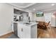 Open-concept kitchen with white cabinets, a peninsula with bar seating, and view to a dining area at 850 Grove St, Denver, CO 80204